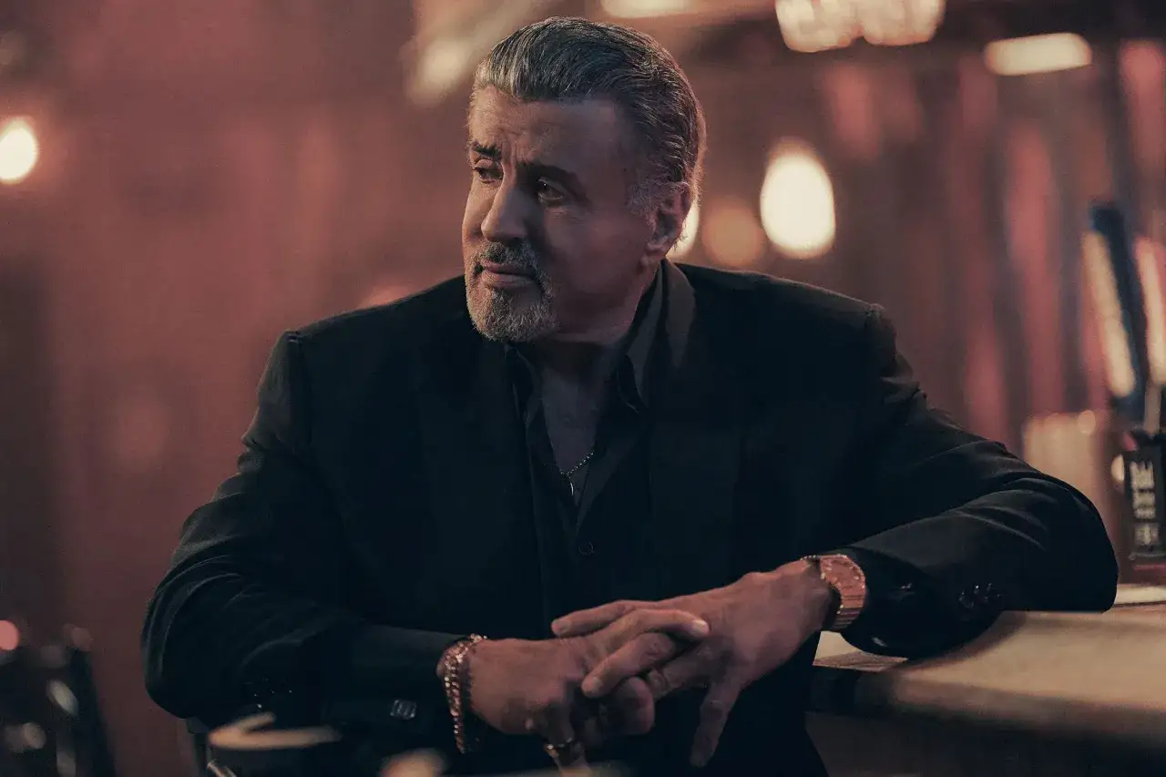 Sylvester Stallone als Dwight Manfredi in Tulsa King Staffel 4, nachdenklich in einem dunklen Anzug.