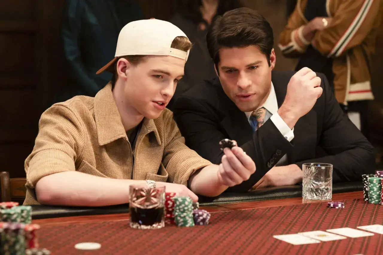 Zwei Männer spielen Poker. Der eine trägt eine Kappe, der andere einen Anzug. Ein spannender Moment in