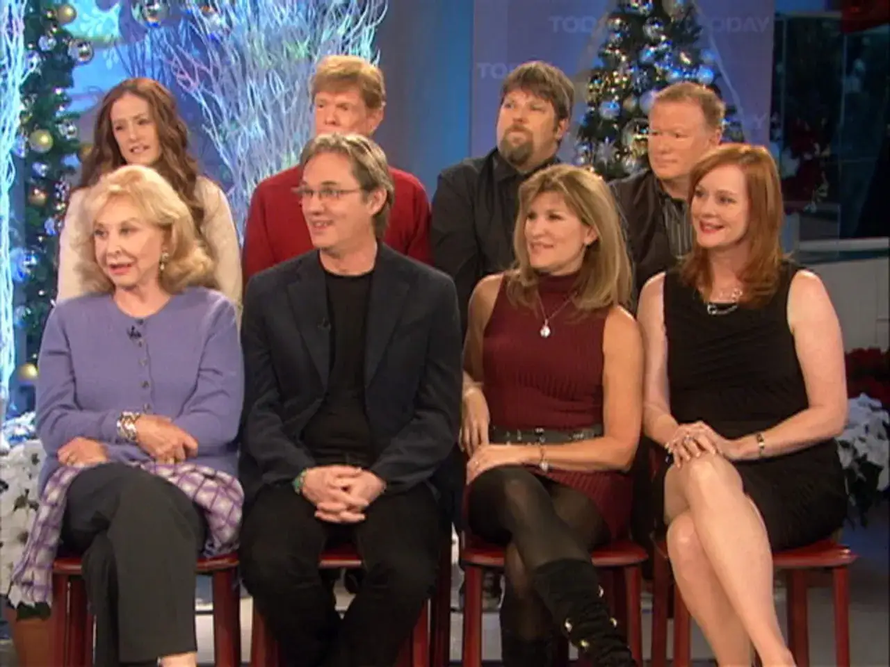 Die Besetzung von Die Waltons sitzt für ein Interview vor Weihnachtsbäumen.