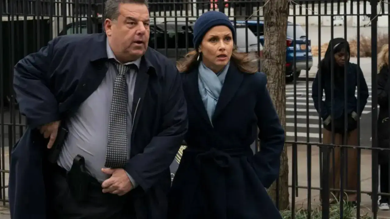 Polizisten in Blue Bloods Staffel 14, ein Mann zieht seine Waffe, eine Frau blickt besorgt.
