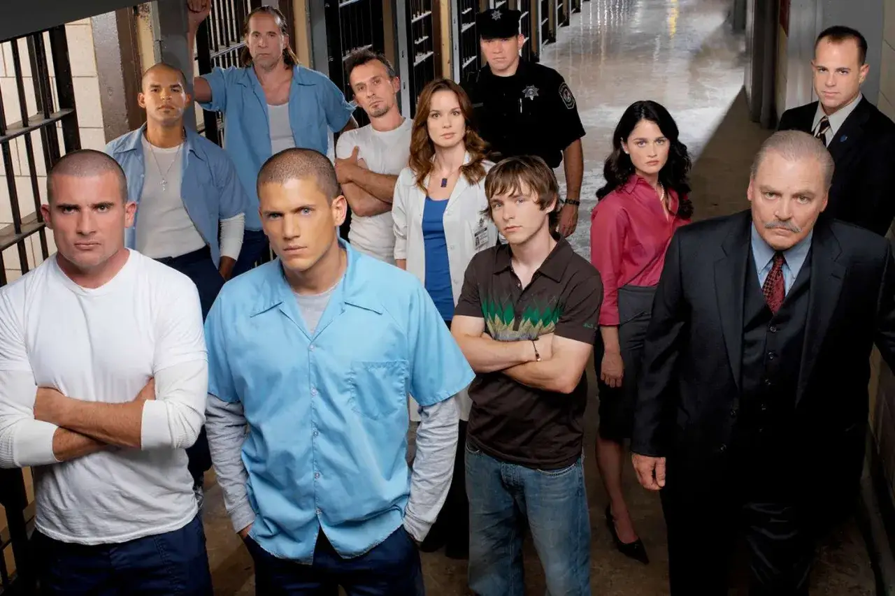Die Hauptdarsteller von Prison Break posieren in einem Gefängnisflur. Michael Scofield und Lincoln Burrows stehen im Vordergrund.