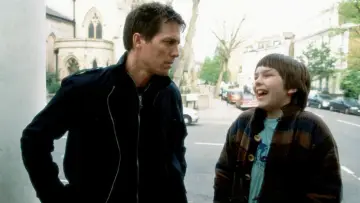 Nicholas Hoult lacht mit einem Mann auf der Straße. Ein Ausschnitt aus seinen Filmen und Serien.