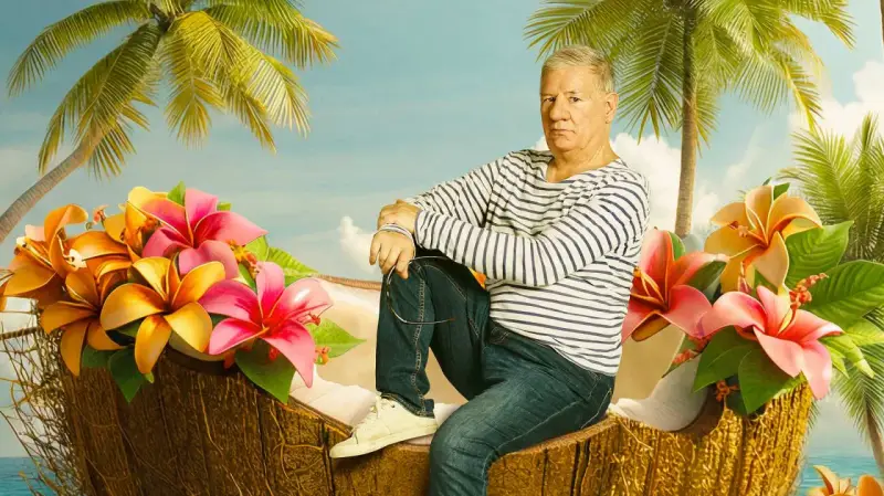 Ein Mann sitzt in einer Kokosnussschale, umgeben von tropischen Blumen und Palmen. Ein Bild, das an Filme von Claude-Oliver Rudolph erinnert.
