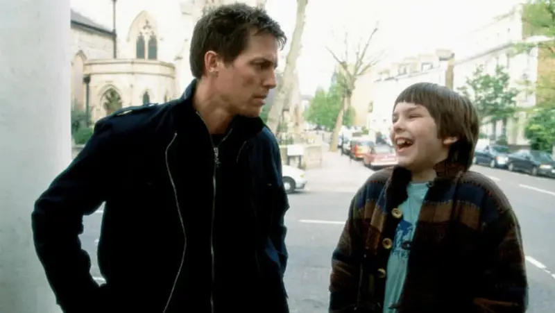 Nicholas Hoult lacht mit einem Mann auf der Straße. Ein Ausschnitt aus seinen Filmen und Serien.